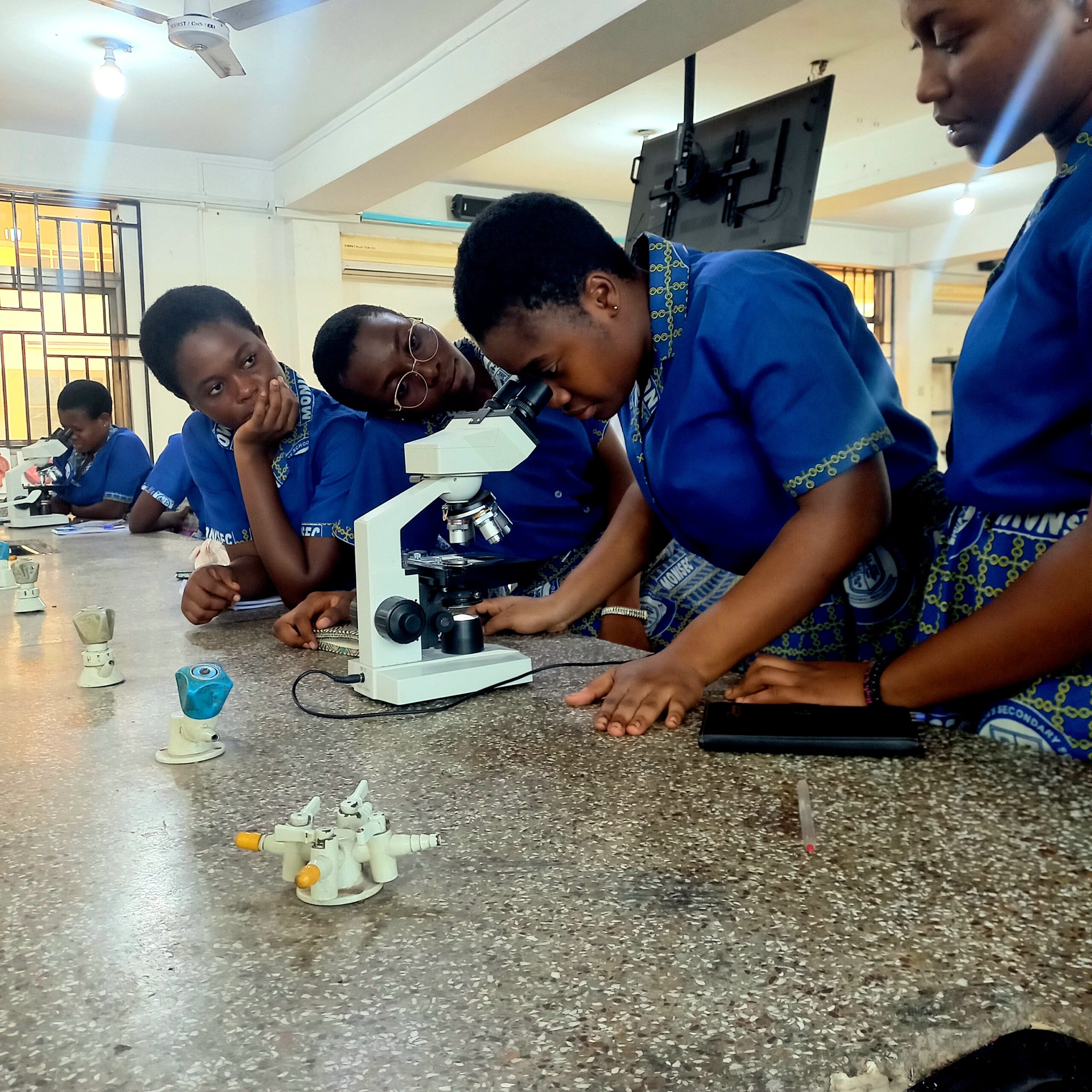Students using a microscope for the Breakthrough Junior Challenge 2026 science scholarship article